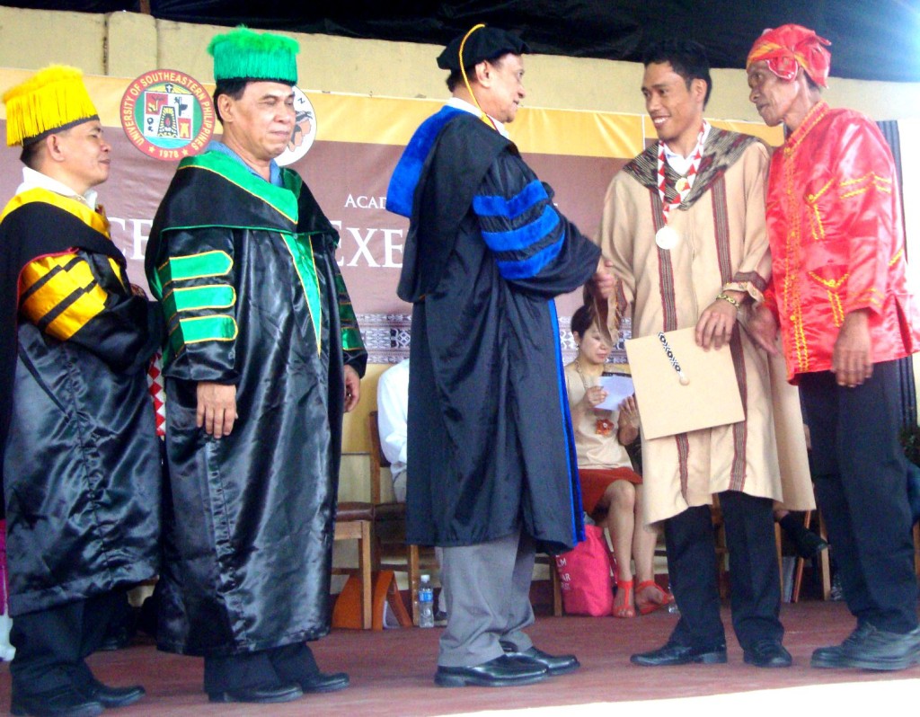 Normindo Mosela (second from right) receives his award while congratulated by State Universities and Colleges President Dr. Perfecto Abilin and other school officials