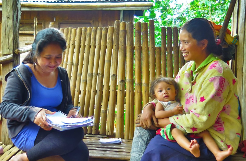 A research assistant interviews the parent of program learners at the family’s home in Miarayon